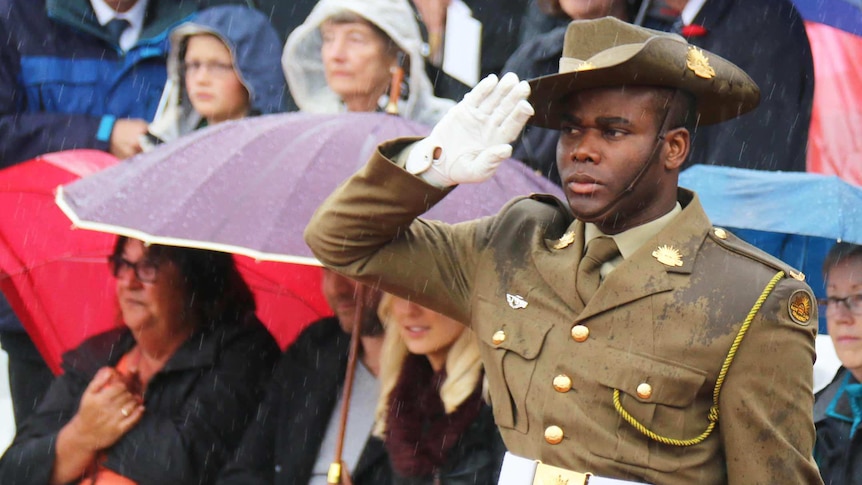 A soldier salutes in the rain.