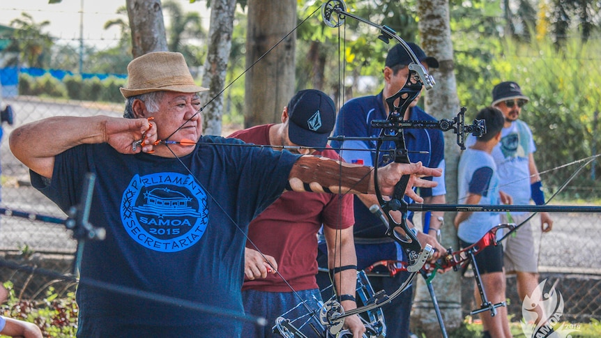 Samoan PM Tuilaepa Sailele is wearing casual clothes and shooting an arow