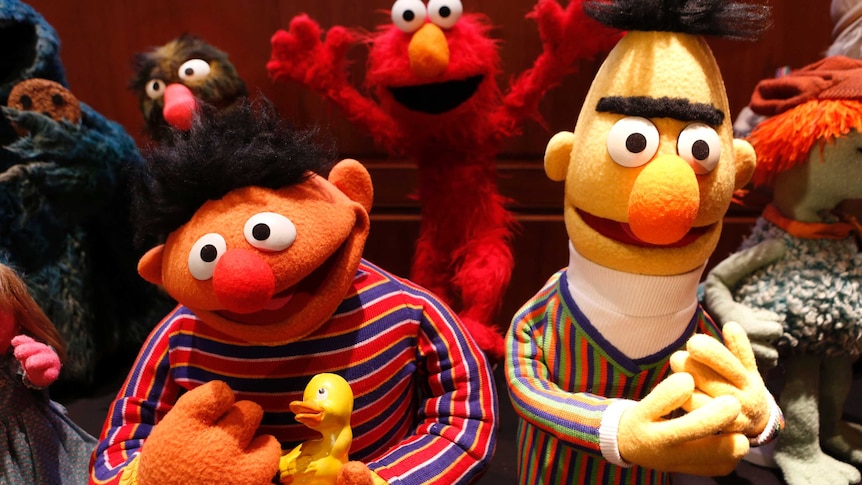 Ernie holding a duck and Bert.