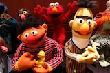 Ernie holding a duck and Bert.