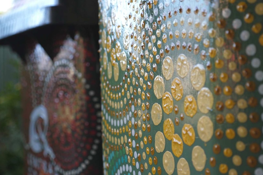 A close up shot of paint dot art on a garbage bin