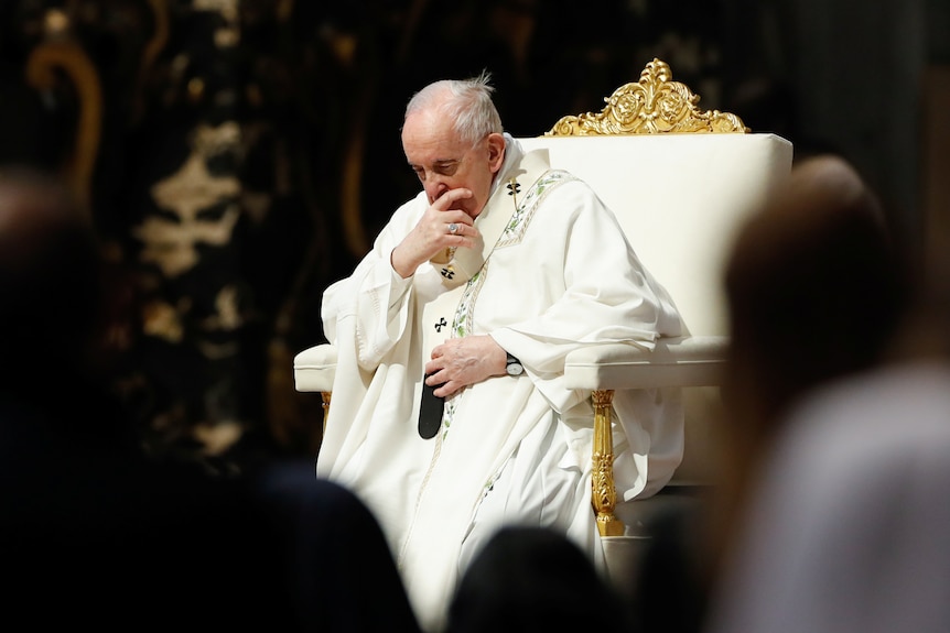 Pope Francis seated at The Vatican, head bowed and pensive