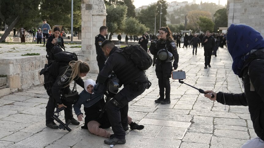 Israeli police arrest an elderly Palestinian woman at the Al-Aqsa Mosque.