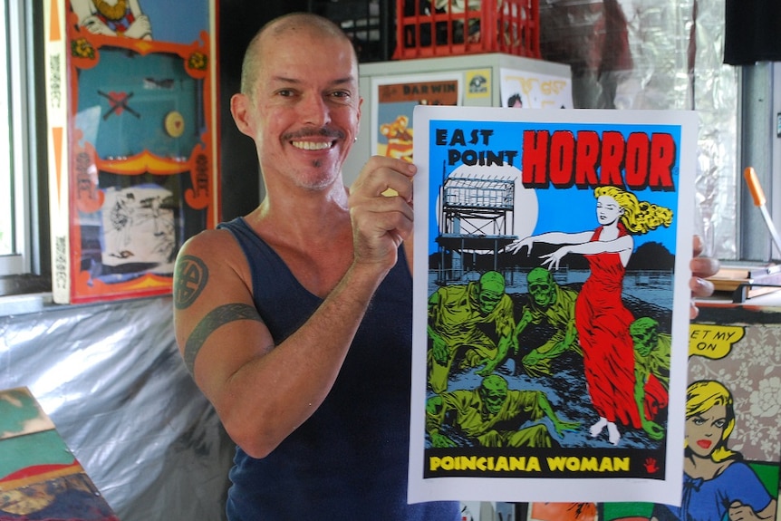 Artist Franck Gohier holds a picture of the Poinciana Woman.