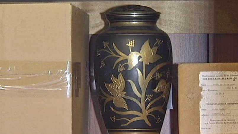 An urn holding cremated ashes on a shelf. Many crematoriums store remains than have not been collected by families.