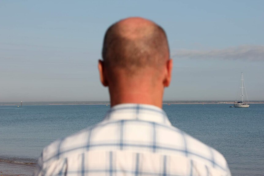 A photo of Michael Wells' head with the harbour in focus in the background.