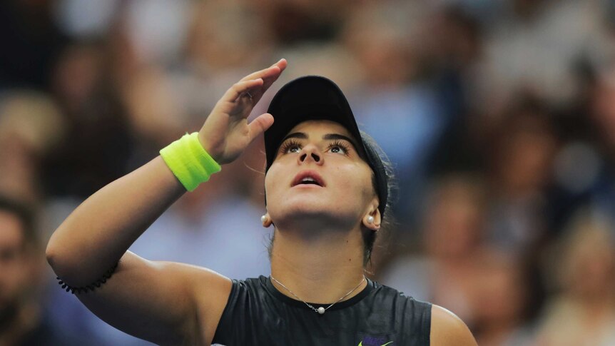 Head and shoulders shot of Bianca Andreescu raising a hand and looking to the sky