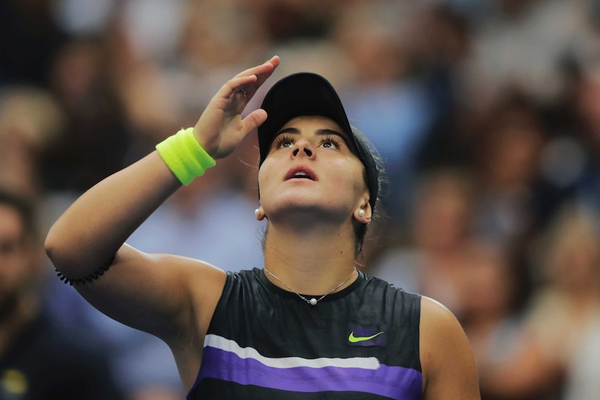 Head and shoulders shot of Bianca Andreescu raising a hand and looking to the sky