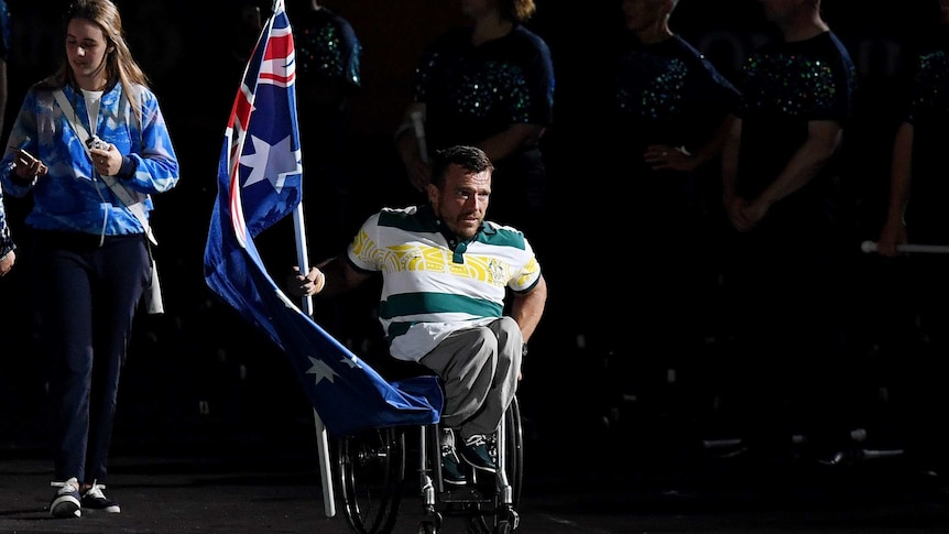 Australian flag bearer Kurt Fearnley enters the stadium at Carrara