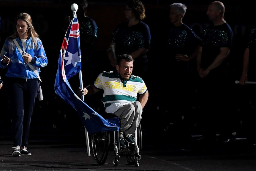 Australian flag bearer Kurt Fearnley enters the stadium at Carrara