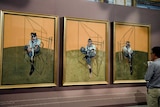 A man looks at the Francis Bacon painting, Three Studies of Lucian Freud, 1969.