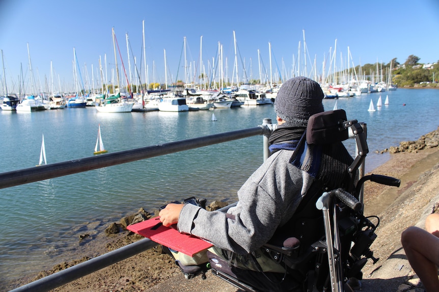 A man looks at the boats in the water.