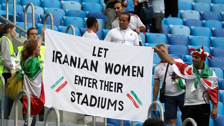 People supporting Iranian women are holding a banner at the stands during the Group B match between Morocco and Iran.