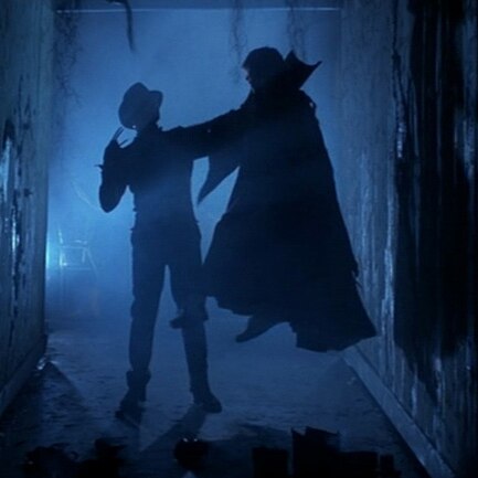 A still from Nightmare On Elm Street 3: Dream Warriors showing Freddy Kreuger holding up a victim.