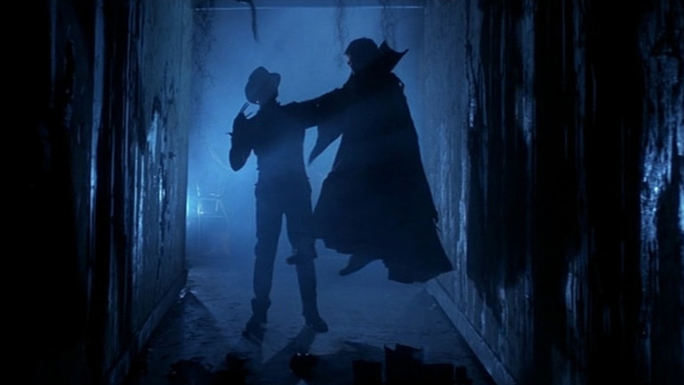 A still from Nightmare On Elm Street 3: Dream Warriors showing Freddy Kreuger holding up a victim.