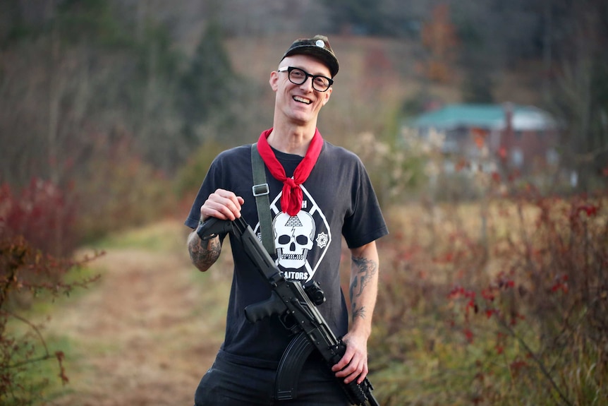 Dwayne Dixon, a member Redneck Revolt, poses with a gun on a North Carolina property.