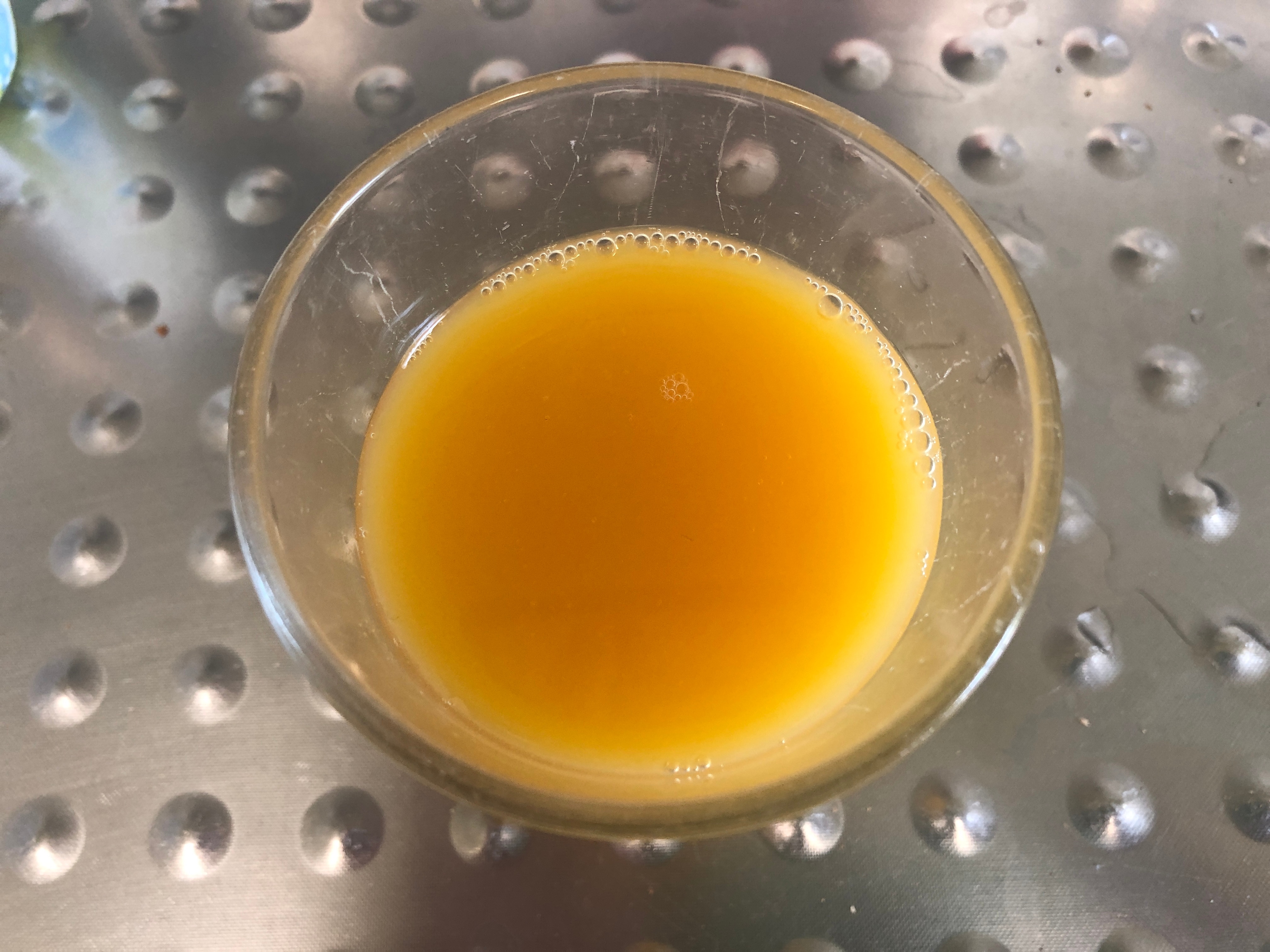 Top view of a glass of orange juice.