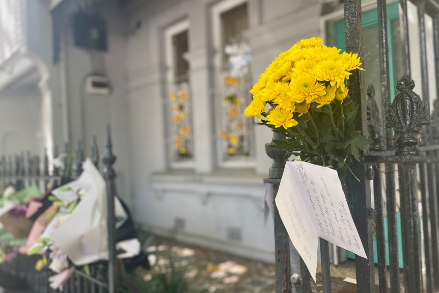 Flowers left on a gate outside a house