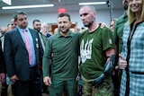Zelenskyy stands with a soldier for a photo.