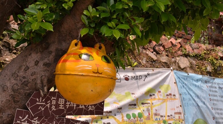 A ball-shaped cat sculpture hangs in a tree in Taiwan's cat village Houtong.