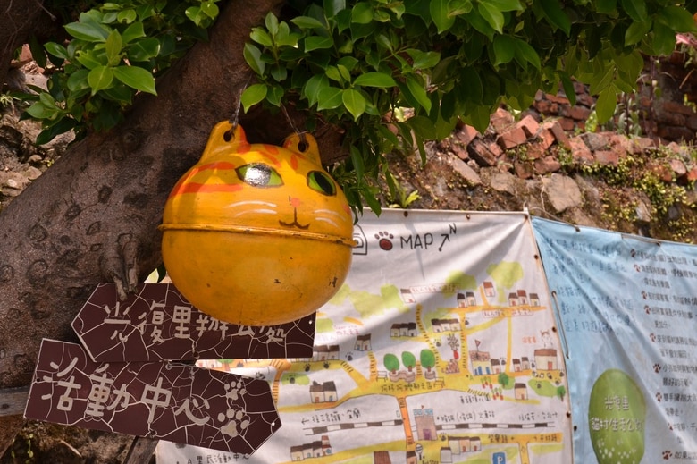 A ball-shaped cat sculpture hangs in a tree in Taiwan's cat village Houtong.
