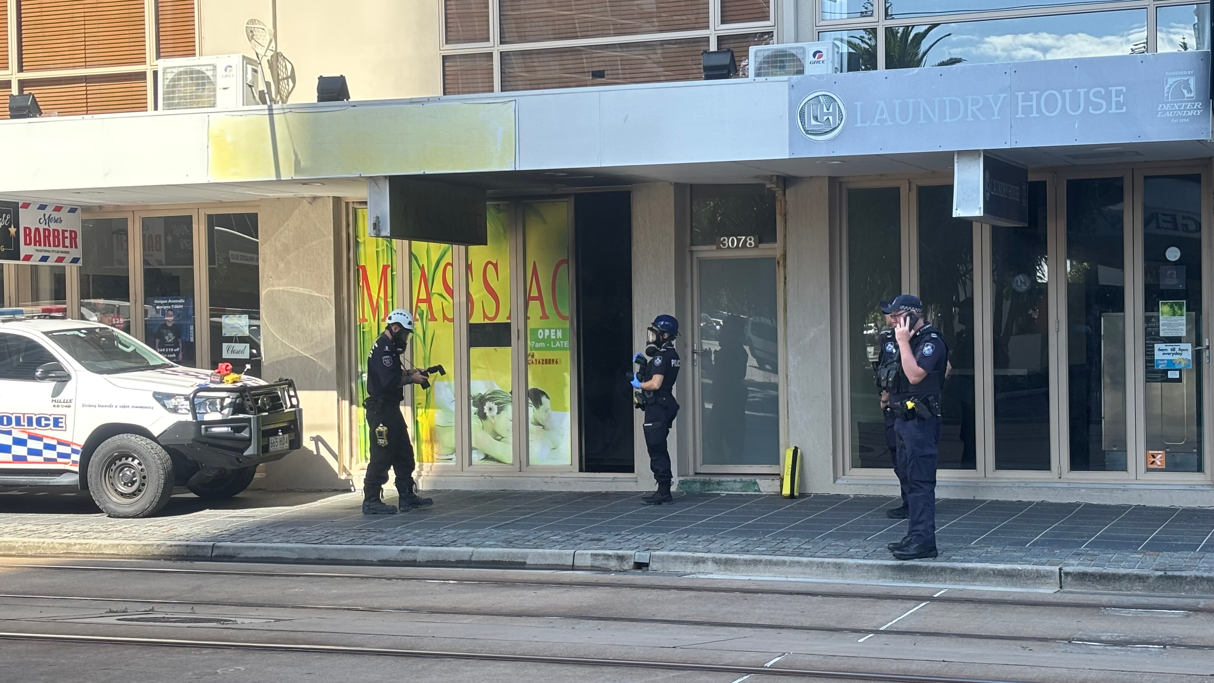 Police stand outside a massage parlour business. 