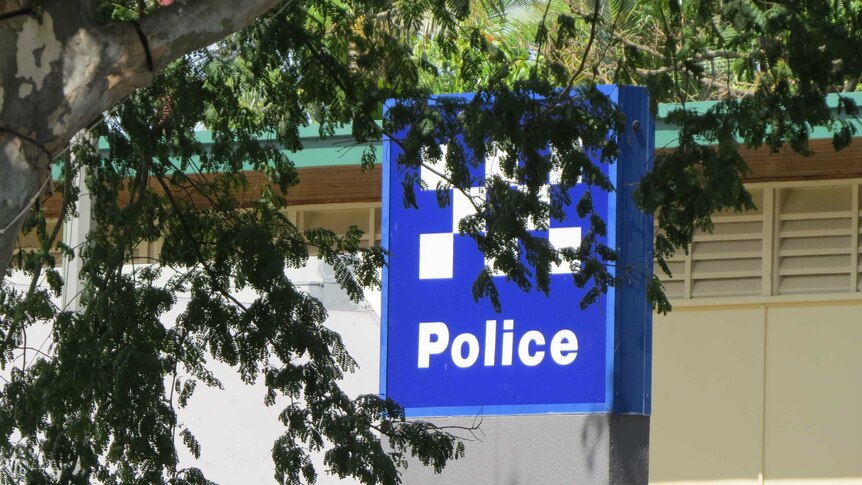 Signage outside Caboolture police station, partly covered by trees