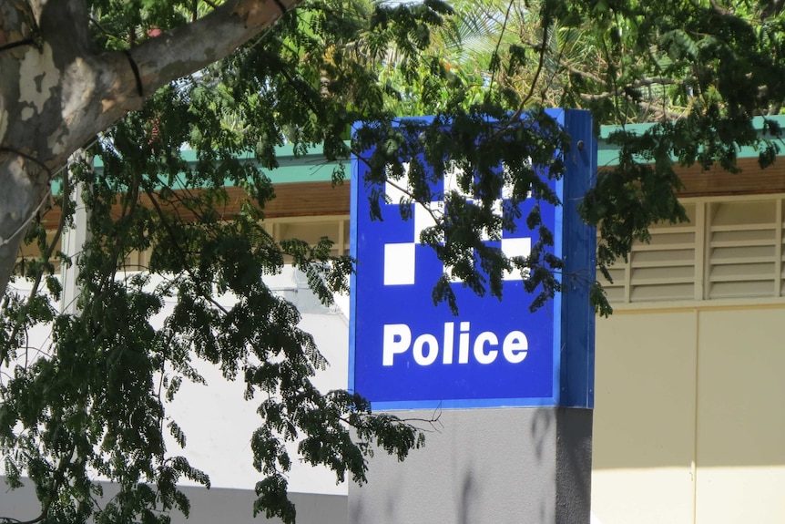 Signage outside Caboolture police station, partly covered by trees
