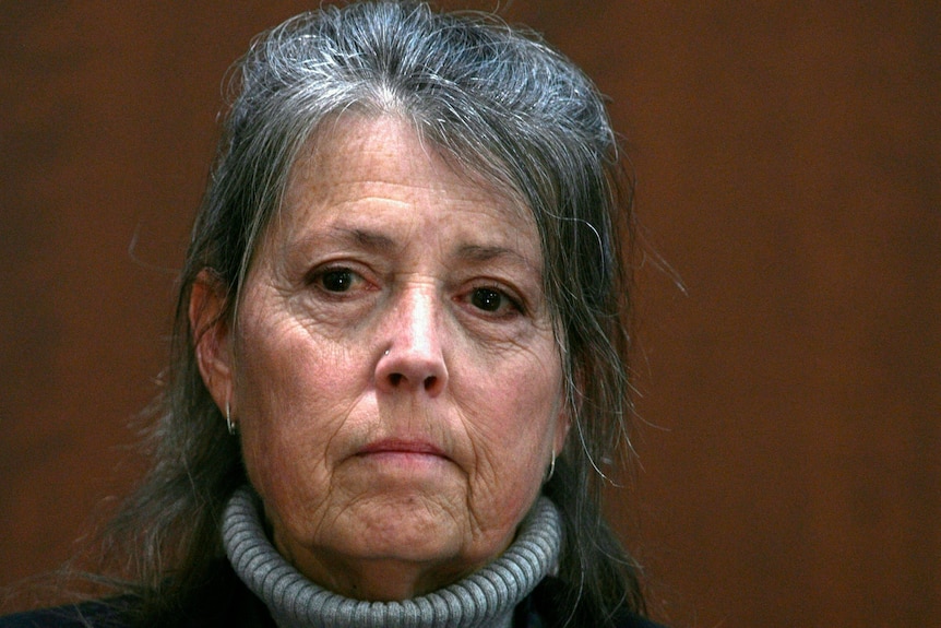 A woman with dark grey hair in courtroom.