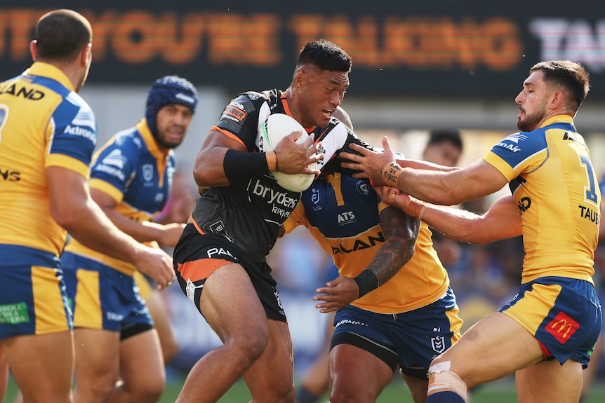 A player runs the ball during a rugby league match