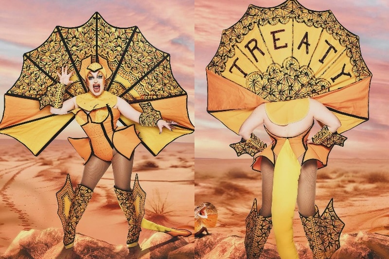 Hannah Conda against a desert backdrop in an orange corset with a frilled neck. The word treaty is on the back.