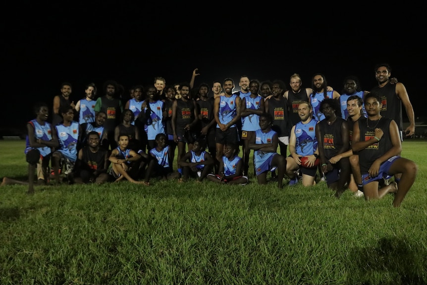 Team football photo on oval at night 