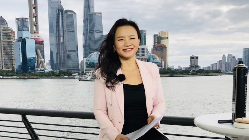 A woman in Shanghai wears a black dress and pink jacket.