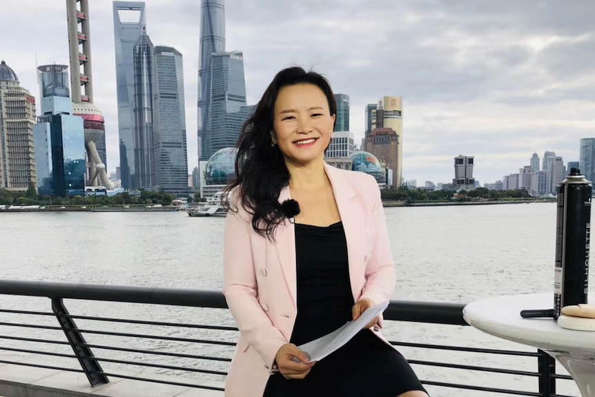 A woman in Shanghai wears a black dress and pink jacket.