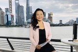 A woman in Shanghai wears a black dress and pink jacket.