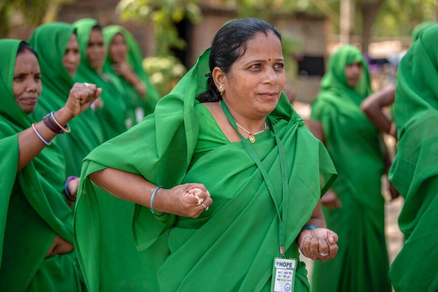 A woman in a green sari practices her karate moves