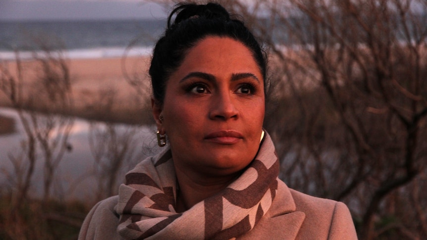 Close up shot of a woman of middle-eastern appearance in sunset light on a beach