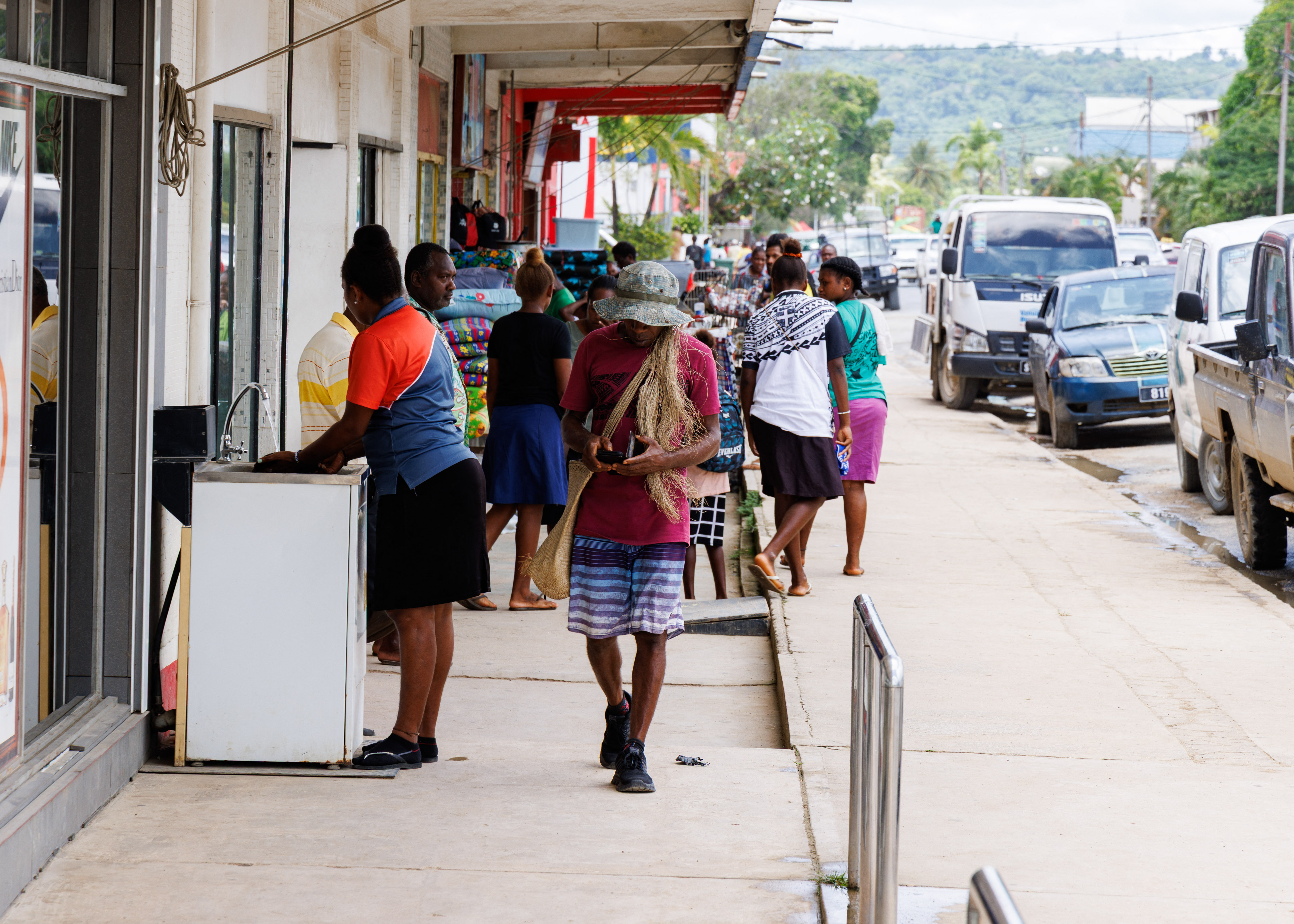 People walk on a busy street in Vanuatu.