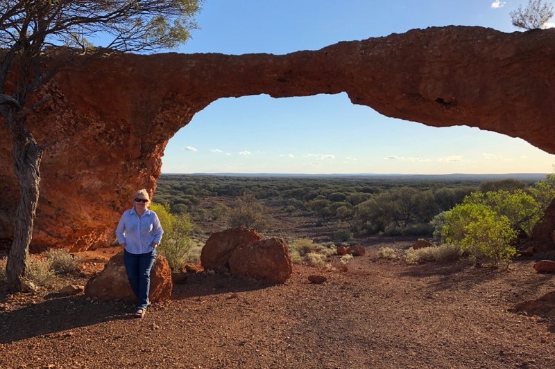 Sandstone Shire President Bethel Walton standing in front of a natural rock formation.