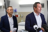 A photo of Mark McGowan and Roger Cook in a hospital room.