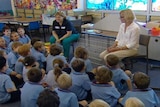 Generic TV still of anonymous Qld primary school children seated on floor of unidentified classroom