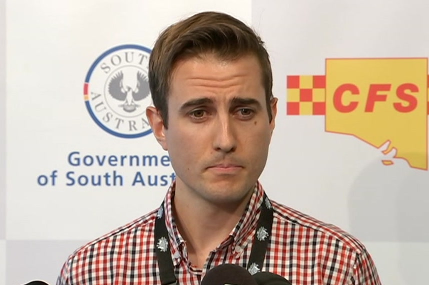 A man speaks into a microphone at a lectern