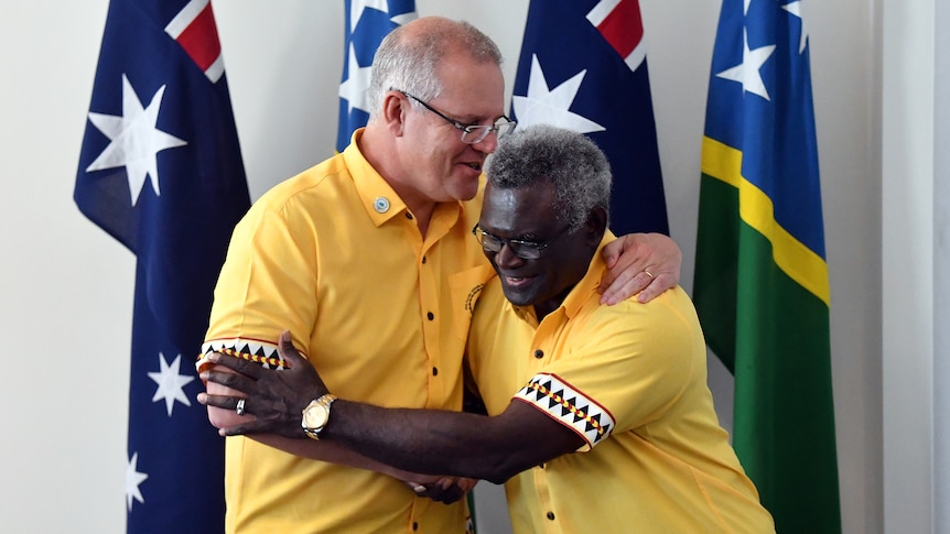 two men, shaking hands and smiling 