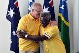 two men, shaking hands and smiling 