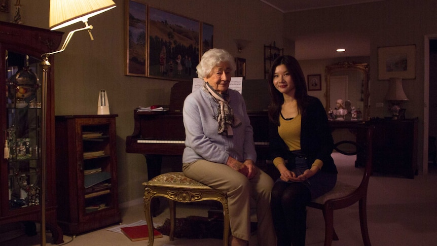 Barbara and Yin sitting by the piano in Barbara's home.