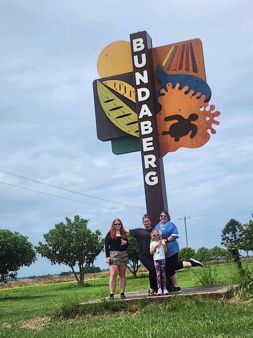 Four women and girls in front of Bundaberg sign