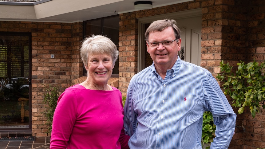 A male and female married couple smile at the camera