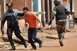 Malian security forces and a hostage rescued from the Radisson Blu hotel run.
