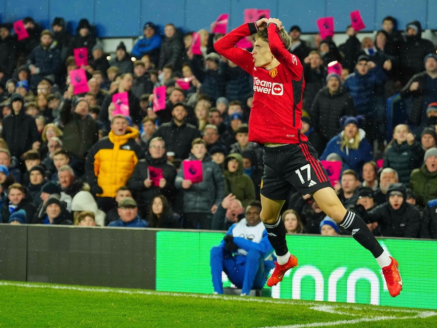 A Manchester United poses as he is about to land a celebratory leap after scoring a Premier League goal.