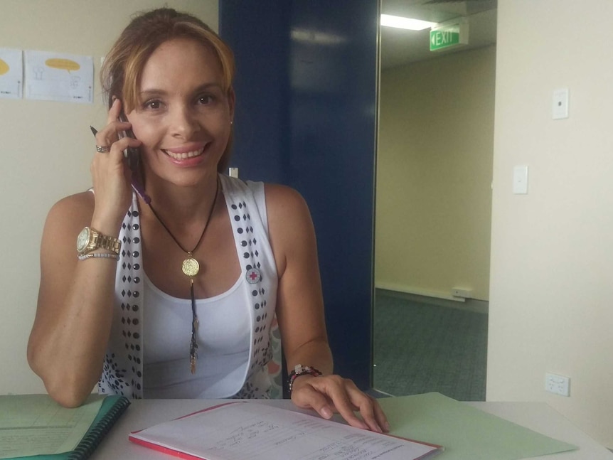 A young women holds mobile phone to her ear to chat to a Spanish speaking client.